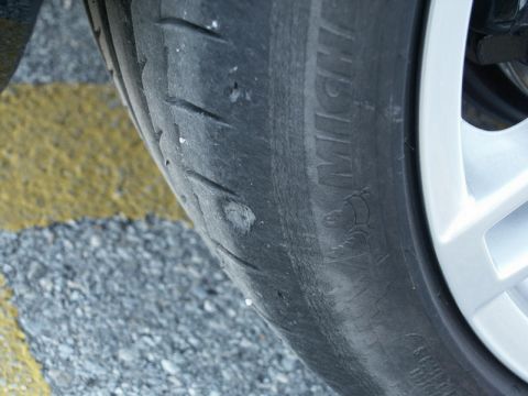 2001 Mercury Grand Marquis - A close-up view of a tire shows significant wear and damage to the tread.