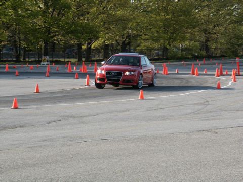 2001 Mercury Grand Marquis - A red Audi sedan is driven through a course outlined by traffic cones on an asphalt lot.