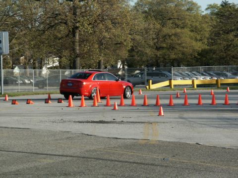 2001 Mercury Grand Marquis - A red sedan is shown driving through a course marked by orange traffic cones.