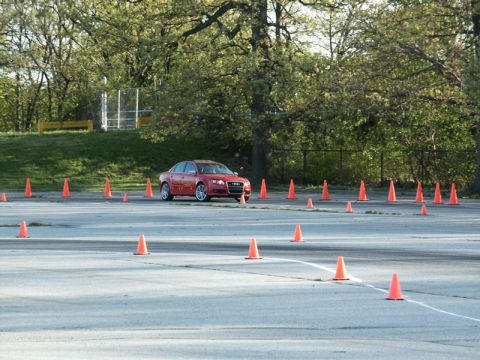 2001 Mercury Grand Marquis - A red Audi sedan is shown on a paved lot with numerous orange traffic cones set up for a driving course.