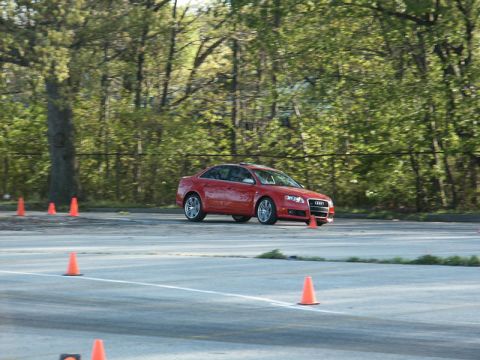 2001 Mercury Grand Marquis - A red Audi sedan drives through a course marked by orange cones on a paved track.