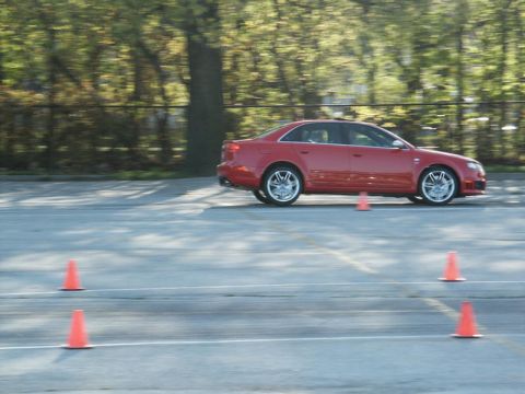 2001 Mercury Grand Marquis - A red sedan navigates a course marked by orange traffic cones on a paved surface.
