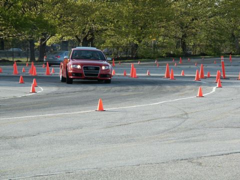 2001 Mercury Grand Marquis - A red Audi sedan navigates a cone course, with another vehicle visible in the background.