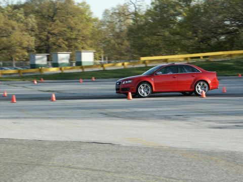 2001 Mercury Grand Marquis - A red Audi sedan drives around a track with orange cones marking the course.