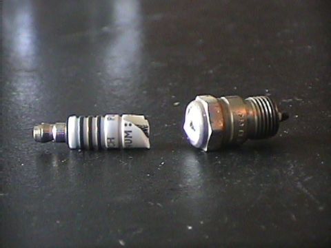 1994 Ford Bronco - Two spark plugs are shown, one with visible text and the other a metallic component.