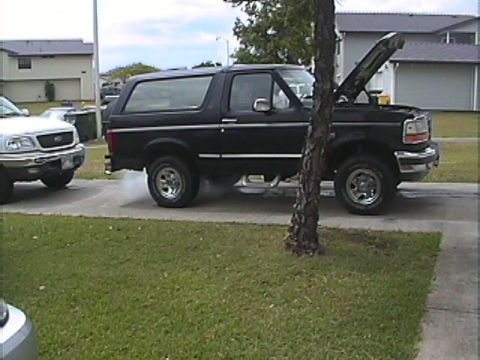 1994 Ford Bronco - 1994 Ford Bronco with hood open, next to a white Ford F-150.