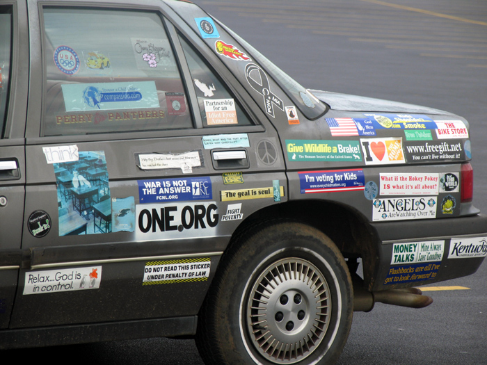 Side view of a car covered in political and social commentary stickers