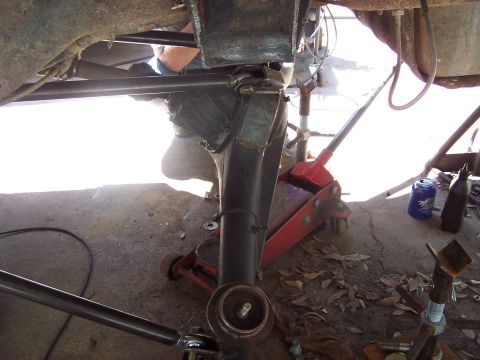 1987 Ford Bronco - Custom suspension work is underway on a vehicle, supported by jacks and stands.