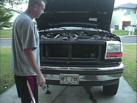 1994 Ford Bronco - Front view of a man standing next to a truck with its hood up, revealing the engine compartment.