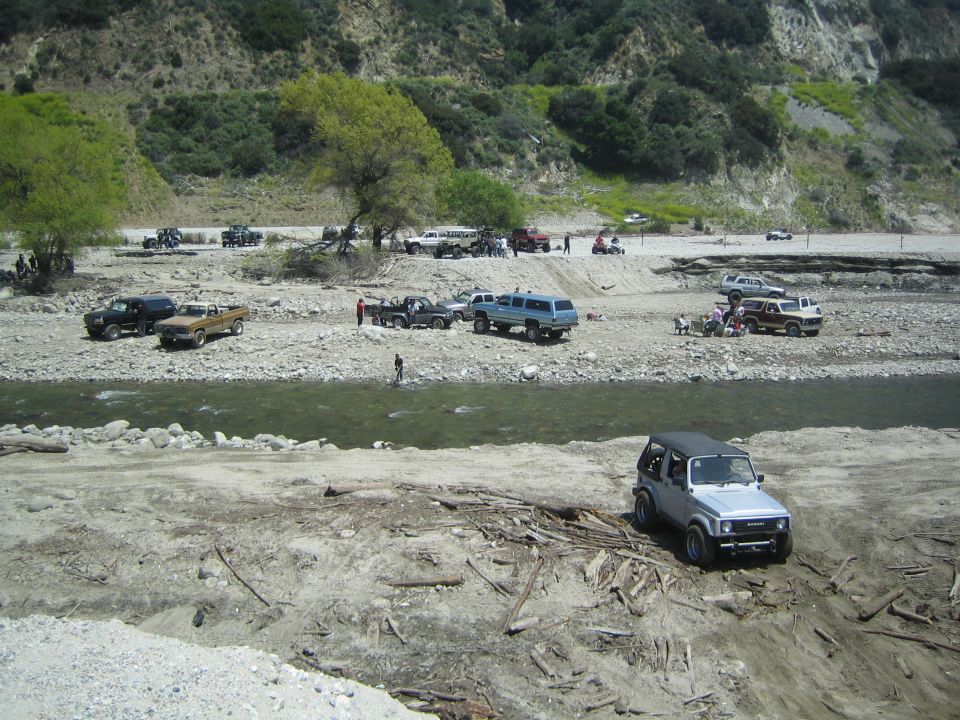 Silver 1987 Suzuki Samurai parked on dirt with debris