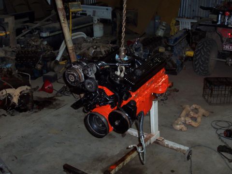 1981 Ford F-150 - An engine is suspended by a chain in a cluttered garage environment.