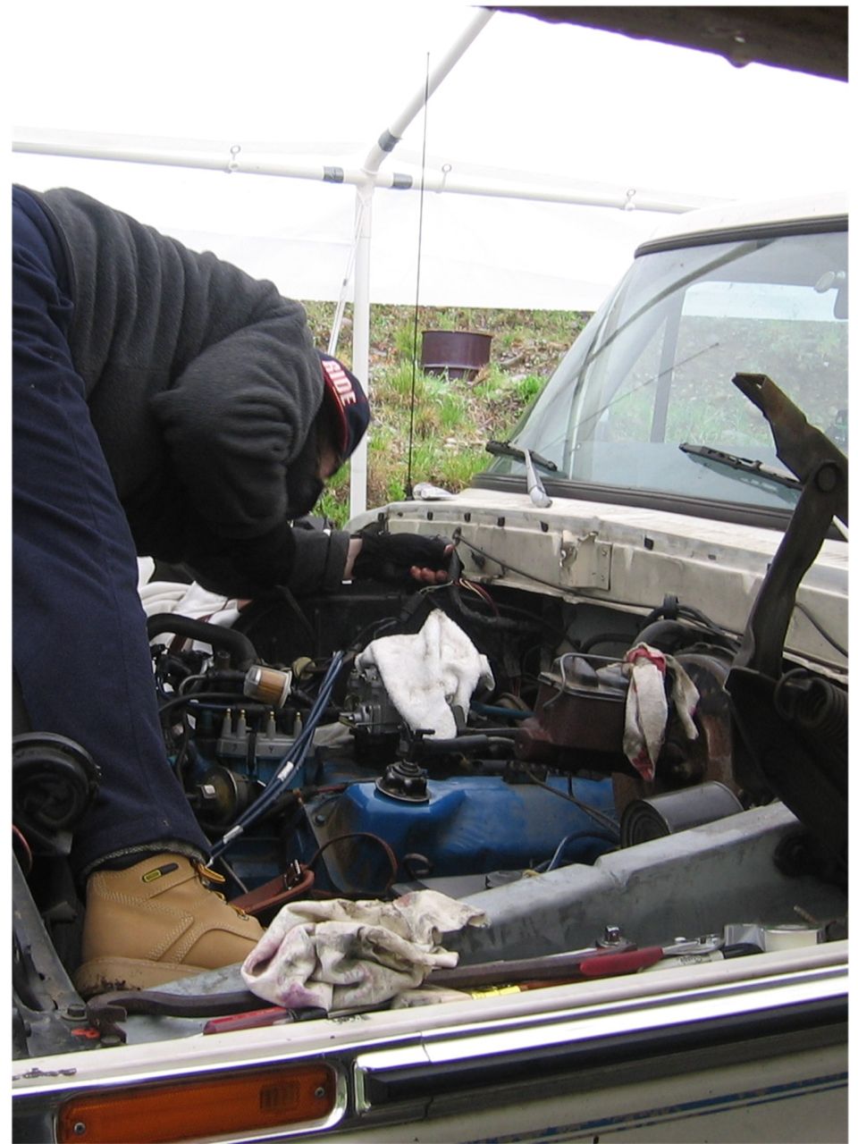 1979 Ford Bronco engine bay with mechanic working
