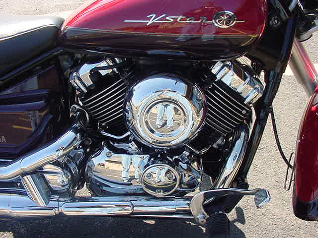 Chrome V-twin engine of a maroon Yamaha V-Star motorcycle with tank logo