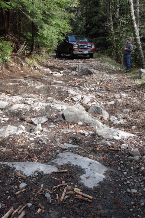 2006 Ford F-250 - Ford Super Duty truck navigates a challenging, rocky trail in a wooded area.