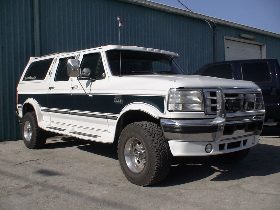 White and green Ford Centurion conversion truck, 3q front view, brush guard and chrome wheels