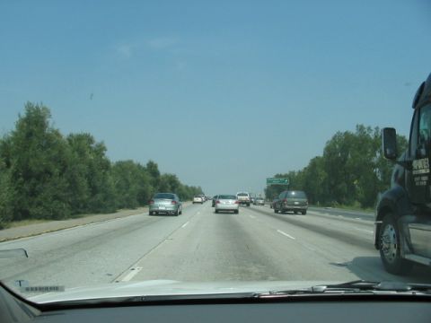 1991 Ford Bronco - Driving on a highway with multiple vehicles in traffic under a clear blue sky.