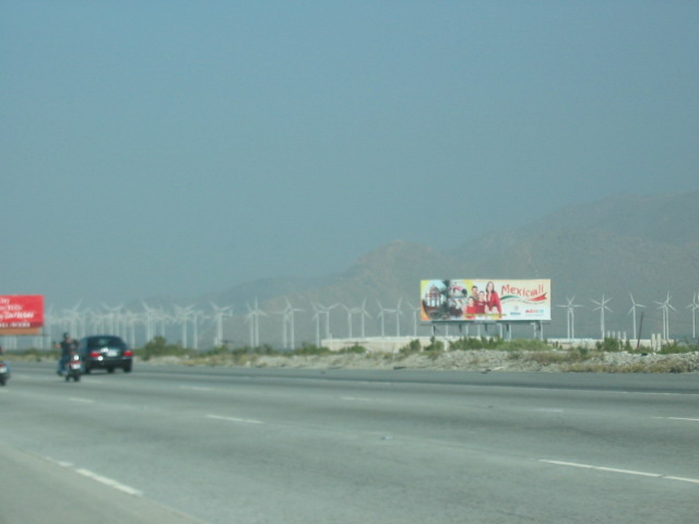 Billboard advertising Mexicali with wind turbines in background