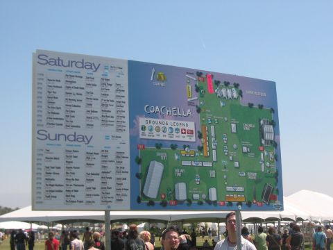 1991 Ford Bronco - A large sign displays the Coachella festival map and schedule for Saturday and Sunday.
