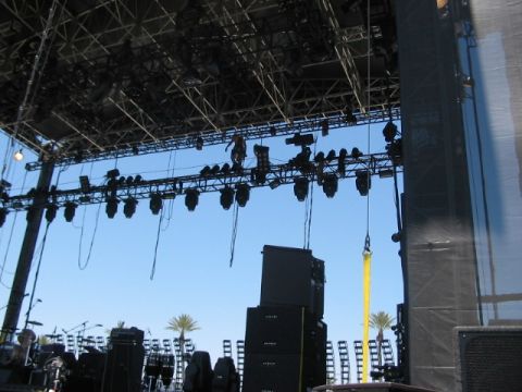1991 Ford Bronco - A large outdoor stage setup with complex lighting and sound equipment is visible against a bright blue sky, with palm trees in the backgrou…