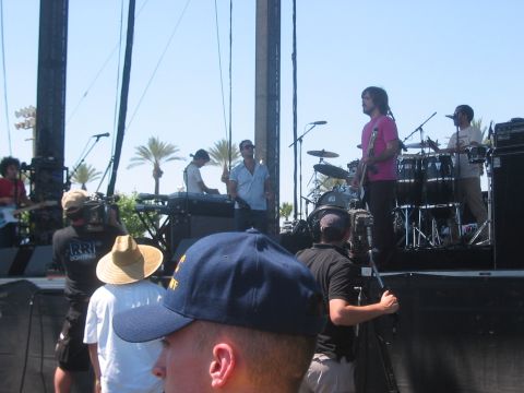 1991 Ford Bronco - A band performs on stage at an outdoor event, with crew members filming the show.