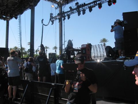 1991 Ford Bronco - A live music performance is underway on an outdoor stage with a large crowd in attendance.