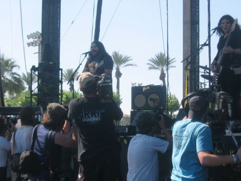 1991 Ford Bronco - A band plays on an outdoor stage while camera operators film the performance.