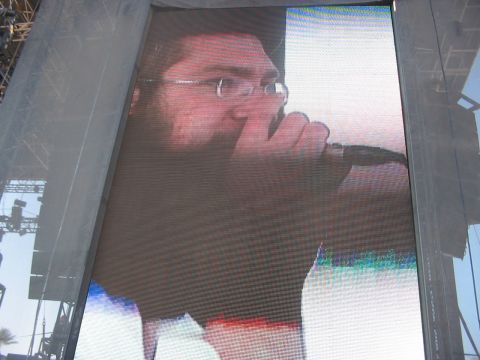 1991 Ford Bronco - A close-up of a man's face and hand on a large outdoor screen.