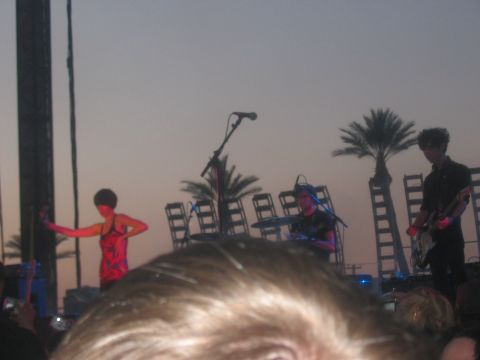 1991 Ford Bronco - A band plays on an outdoor stage at sunset, with palm trees and large speakers in the background.