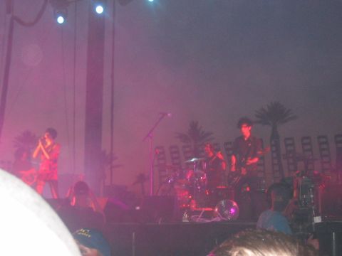 1991 Ford Bronco - A band plays a concert on an outdoor stage, with palm trees visible behind them.