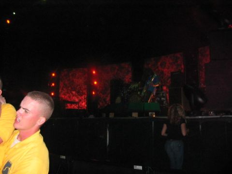 1991 Ford Bronco - A band performs on a dimly lit stage with a dramatic red backdrop, while audience members watch from the foreground.