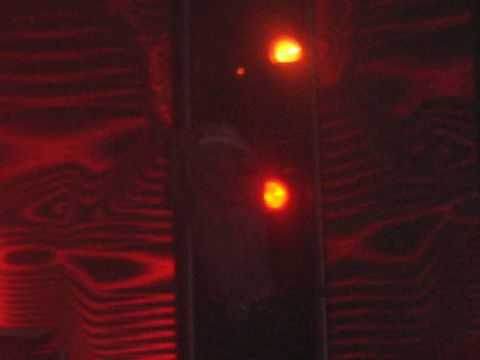 1991 Ford Bronco - The image shows two illuminated red lights against a dark, wood-grain-like background.