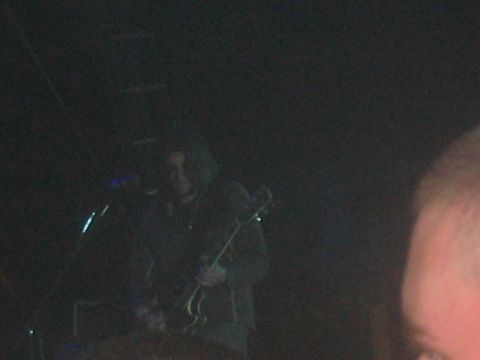 1991 Ford Bronco - A musician performs on stage, illuminated by faint lights.