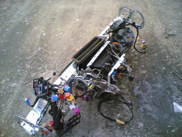 Removed dash crossmember with steering column, HVAC ducts, fuse box and wiring harness on concrete