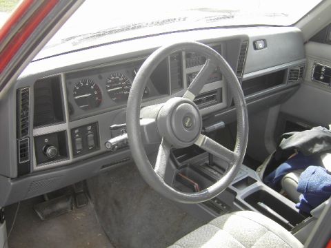 1991 Jeep Cherokee - The interior of a 1991 Jeep Cherokee, its dashboard, steering wheel, and center console.