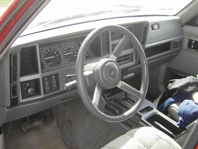 Dashboard and steering wheel of a 1991 Jeep Cherokee. Shows gauges, radio, and center console