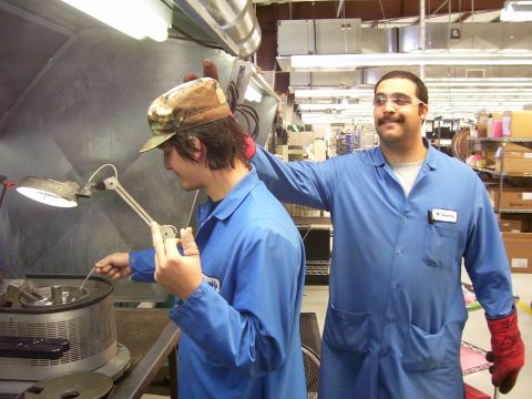 1994 Ford Probe - Workers in a factory setting, one operating machinery while the other supervises.