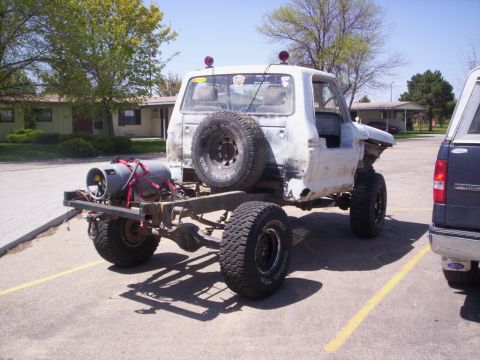 1978 Ford Bronco - This heavily modified truck chassis, possibly from the 1970s, is missing its body panels and has a large gas cylinder attached to the rear.