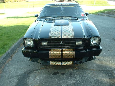1978 Ford Mustang II - Front view of a black 1978 Ford Mustang II Cobra II with distinctive racing stripes.