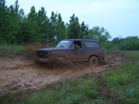1988 Ford Bronco - This 1988 Ford Bronco navigates a muddy trail, kicking up a significant spray.