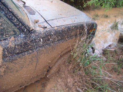 1988 Ford Bronco - Vehicle is stuck in a muddy body of water, with only the front portion visible.