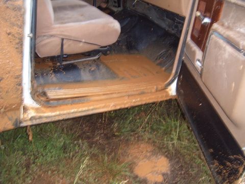 1988 Ford Bronco - The interior of a 1988 Ford Bronco is heavily covered in mud, indicating recent off-road use.