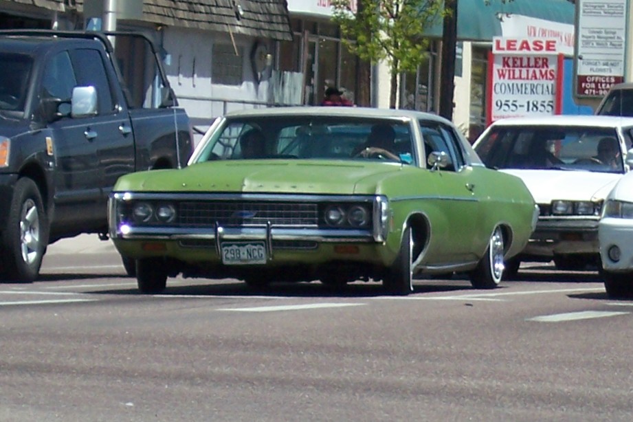 Green 1971 Chevrolet Caprice sedan front view with custom wheels