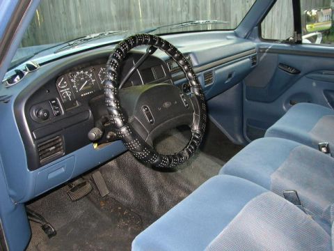 1995 Ford Bronco - Interior view of a 1995 Ford Bronco, blue cloth seats and dashboard.