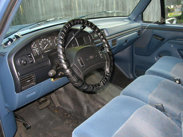 1995 Ford Bronco interior showing blue seats, dashboard, and steering wheel