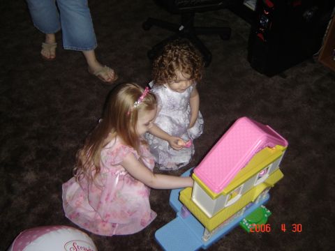 1993 Ford Bronco - Children engage in imaginative play with a colorful toy house, surrounded by toys on a carpeted floor.
