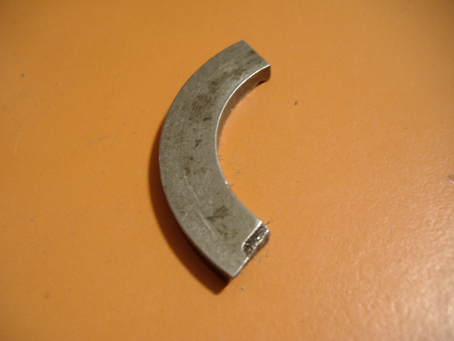 Curved metal shim on orange surface