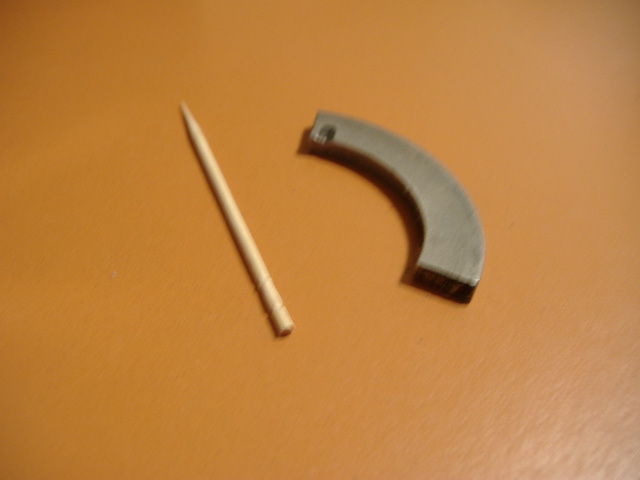 Metal bearing part and toothpick on orange surface