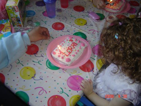 1993 Ford Bronco - A birthday cake with lit candles sits on a table covered with a festive tablecloth.