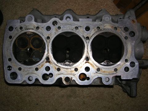 1996 Ford Probe - A used engine cylinder head is shown, with visible wear and tear on the valve seats.