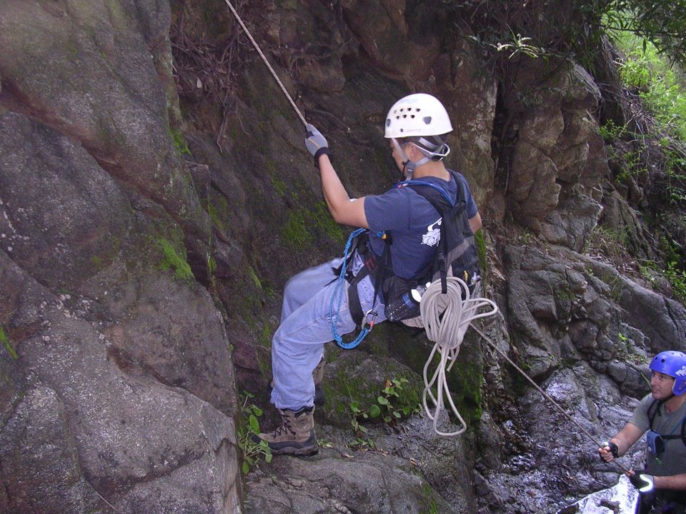 Rock climbing scene with two people rappelling down a rocky cliff